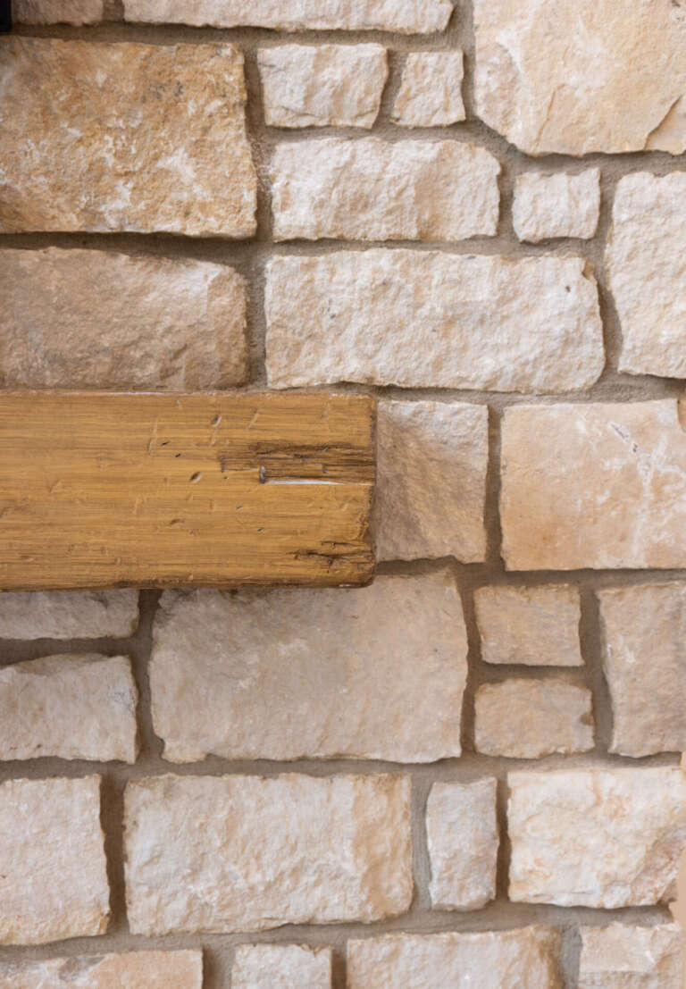 Close-up natural stone material detail of the grand room fireplace surround in the Artful Haven luxury home renovation in Suwanee, GA by Infinite Home